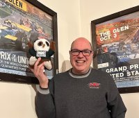Swoop and Mark posing for a picture with some motorsports memorabilia.