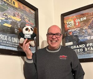 Swoop and Mark posing for a picture with some motorsports memorabilia.