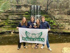 Students with NMC banner at botanical garden